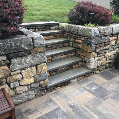 Fieldstone Retaining Wall Topped with Cut Granite and Steps Topped with Bluestone