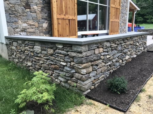 Bluestone patio with a field stone border topped with bluestone