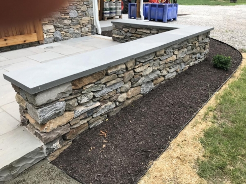 Bluestone patio with a field stone border topped with bluestone