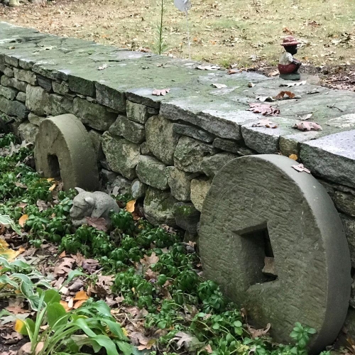 Fieldstone wall with antique well covers