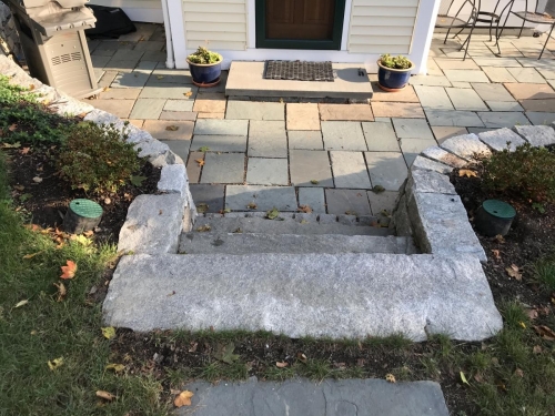 Cut antique granite with a fieldstone retaining wall and bluestone patio