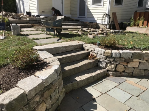 Cut antique granite with a fieldstone retaining wall and bluestone patio