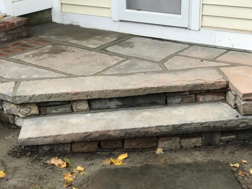 Fieldstone base capped with old bluestone with antique granite edging